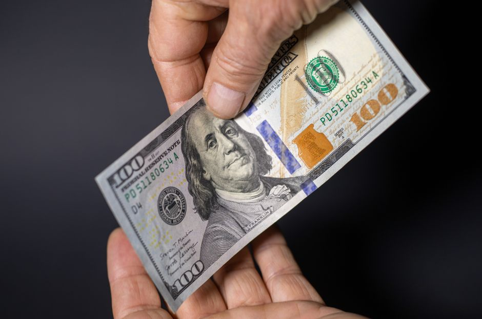 Billete de cien dólares representando las finanzas personales y el sistema crediticio